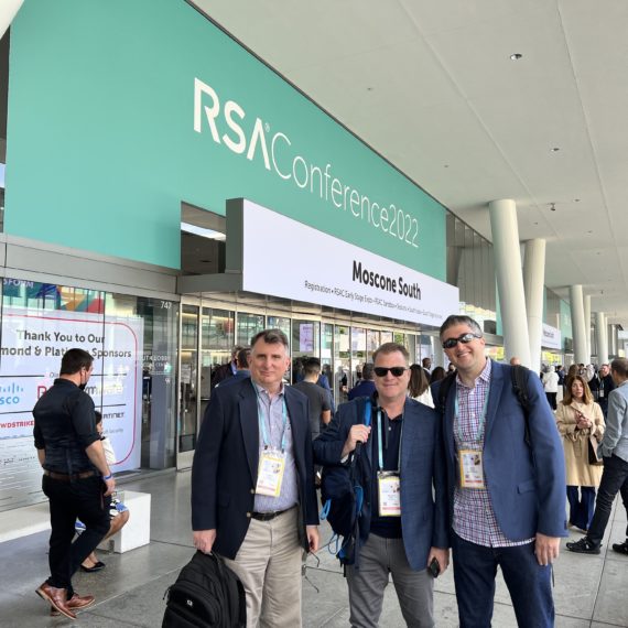 Client Partner Michael Lane with Media and Influencer Leads Andy Shane and Joshua Swarz photographed standingin front of the RSA Conference 2022 sign at the Moscone Center.