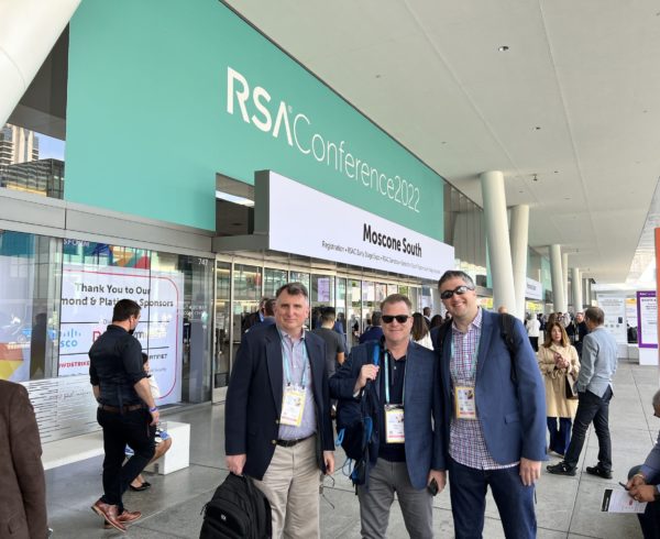 Client Partner Michael Lane with Media and Influencer Leads Andy Shane and Joshua Swarz photographed standingin front of the RSA Conference 2022 sign at the Moscone Center.